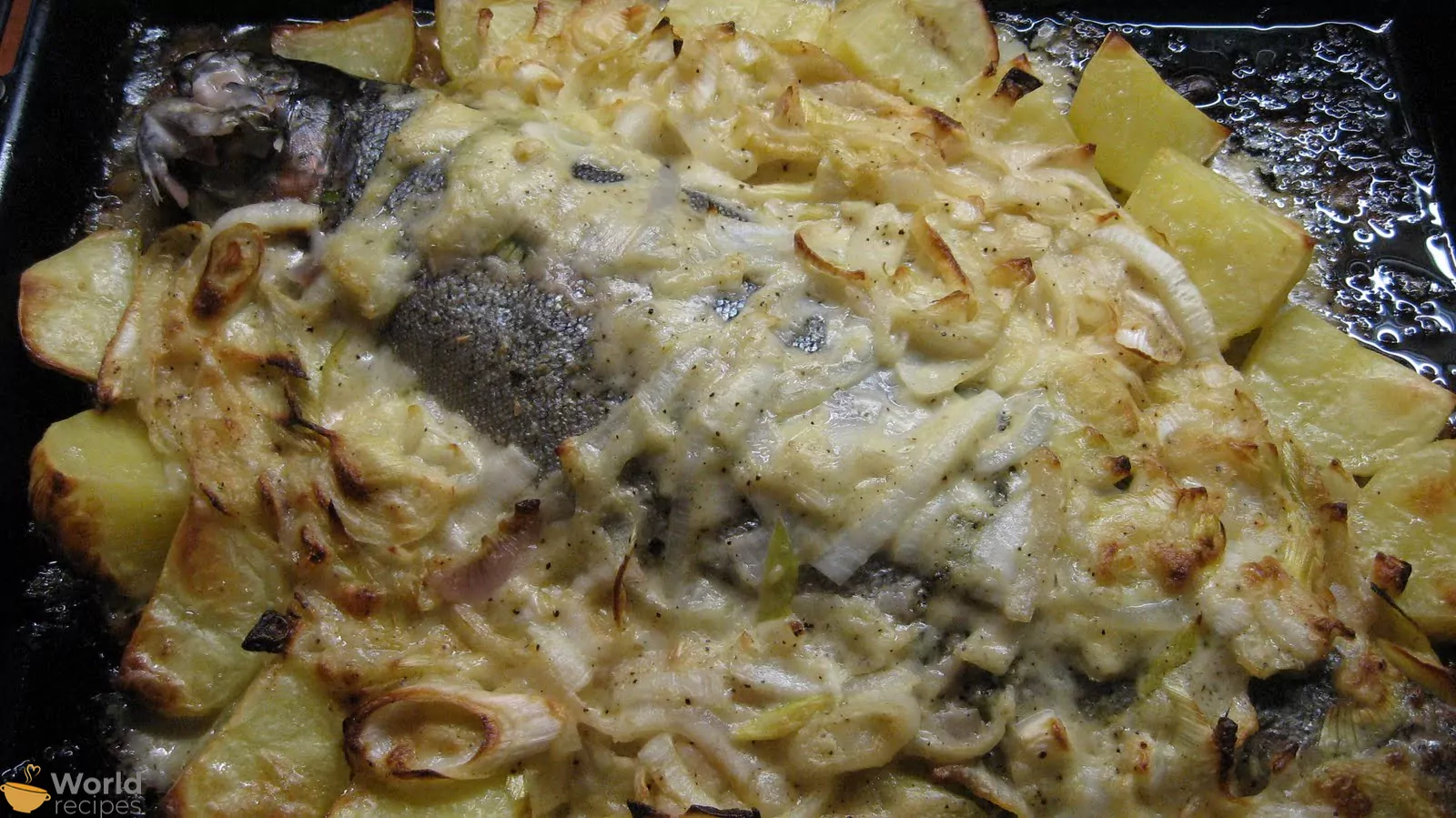 Orkaitėje keptas upėtakis, svogūnų ir porų patale su bulvėmis